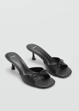 Sandalias rojas de tacón kitten con punta cuadrada y detalle de lazo decorativo.