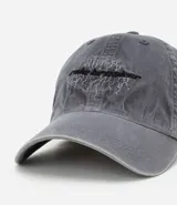 Gorra gris de sarga de algodón con efecto desteñido, visera curva y ajuste trasero con hebilla. Presenta bordado frontal con la frase "rule breaker" simulando rayos.