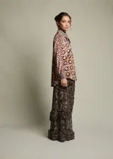 Camisa holgada de terciopelo elastizado con estampado floral y geométrico en tonos borgoña, amarillo y celeste. Corte clásico con cuello solapa y abotonada.