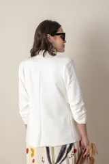 Blazer beige de algodón con solapa entera, bolsillos delanteros y frunce en las mangas 3/4.