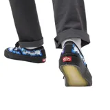 Zapatillas Vans Authentic 44 DX con estampado de calaveras y llamas en tonos azules sobre fondo blanco.