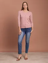 Cardigan tejido en hilado fino, color rosado, con escote redondo y cierre frontal con botones.