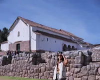 Chaleco color crema con cuello y borde de cuero marrón, con cierre de botones y bolsillos frontales.