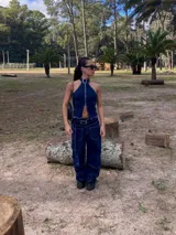 Pantalón de jean azul de tiro alto, corte ancho y denim rígido. Incluye cinturón y tiras desmontables.