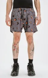 Short de baño gris con estampado de calaveras, dagas y llamas en tonos naranja y negro.