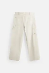 Pantalón color marrón con efecto lavado, corte relaxed fit, cinco bolsillos, aplicación de tira y bolsillo multifunción en perneras, cierre frontal con cremallera y botón.