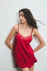 Conjunto de pijama de satén rojo, compuesto por un top con breteles finos y detalle de encaje en el escote, y un short con cintura elástica.