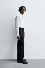 Pantalón de vestir negro de lana, corte recto, con bolsillos laterales y traseros de ojal con botón.