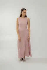 Vestido midi rosado sin mangas, con cuello redondo y corte trapecio. Presenta costuras verticales con pespuntes en color rojo. Tiene aberturas laterales en el ruedo.