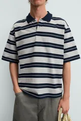 Polo de hombre corte holgado con cuello solapa y cierre de botones. Diseño a rayas horizontales grises y azul marino.