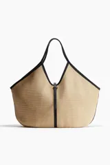 Bolso shopper de paja de plástico trenzada color beige con detalles en tejido revestido negro. Asas estrechas, correa fina en la parte superior y bolsillo interior con cierre.