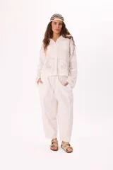 Camisa blanca de algodón con bordado floral, cuello bebé y cierre frontal con botones.