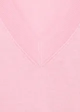 Jersey de punto fino color rosado, de manga larga y cuello en V, con corte recto.