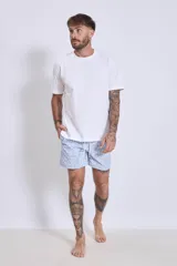 Short de baño celeste con estampado floral blanco, con cintura elástica y cordón ajustable.