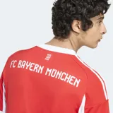 Camiseta de fútbol Adidas del FC Bayern Múnich, modelo Home 25/26. Diseño rojo y blanco con efecto distorsionado que revela la letra M. Cuenta con tejido transpirable AEROREADY y escudo del club bordado.