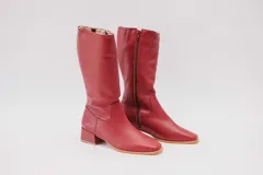 Bota de caña alta de cuero color rojo, con cierre lateral y taco cuadrado de 4 cm.