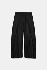 Pantalón wide leg negro de tiro medio confeccionado en hilatura con lino. Presenta bolsillos laterales ocultos en costura, detalle de pinzas en delantero y cierre frontal con cremallera, botón y ganchos metálicos.