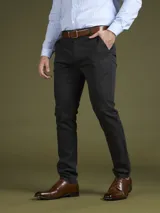 Pantalón de vestir azul marino, de corte slim fit, con bolsillos laterales y traseros. Se ajusta a la cintura con cinturón de cuero marrón.