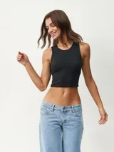 Musculosa corta negra, ajustada al cuerpo, con cuello redondo y sisas amplias.