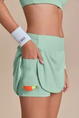 Pollera deportiva color verde lima, con short interno y bolsillo en la cintura.