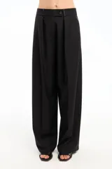 Pantalón negro de vestir, de corte amplio y tiro alto, con pinzas delanteras y cierre con botón.