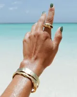 Pulsera tipo esclava abierta, con acabado rústico y textura irregular, en tono plateado. Se vende por unidad.