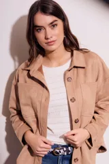 Sobrecamisa negra de gamuza vegana con calce oversize, cuello camisero, cierre con botones a presión, mangas largas con puños abotonados y bolsillos de parche en el pecho.