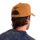 Gorro de gabardina color tostado con paneles de malla color marrón. Presenta bordado frontal con el logo de Caterpillar y la frase "It's time for a Show-Down". Tiene visera curva y cierre ajustable a presión en la parte trasera.