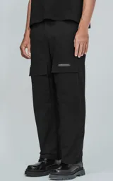 Pantalón cargo negro de corte recto con bolsillos laterales con solapa y etiqueta con texto en la pierna derecha.