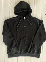 Hoodie negro con capucha y puños ajustados. Estampado en la espalda con dos palmeras y un sol en colores blanco, amarillo y verde oliva.