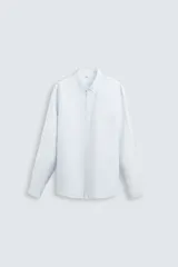 Camisa celeste a rayas verticales, de corte relaxed fit, confeccionada en lino y algodón. Tiene cuello abotonado, manga larga con puños abotonados, bolsillo de parche en el pecho y cierre frontal con botones.