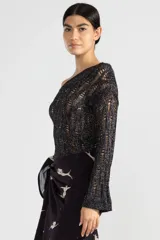 Top negro de tejido calado con un hombro descubierto y manga larga.