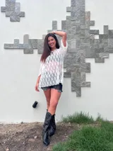 Remerón holgado de encaje blanco, manga corta y cuello redondo. Se usa sobre un top o corpiño oscuro y shorts blancos.