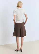 Remera de punto fino color blanco, de manga corta y cuello redondo, corte entallado.