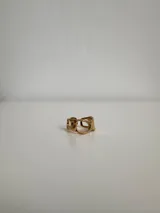 Anillo plateado de acero quirúrgico hipoalergénico con diseño irregular y aberturas circulares.