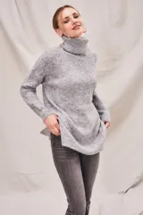 Sweater beige con cuello alto doble, textura acanalada y tajos laterales.