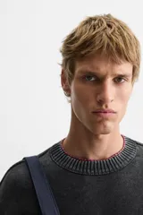 Sweater negro de algodón con cuello redondo, manga larga y terminaciones en rib.