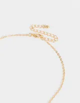 Cadena dorada con dije de corazón con perlas sintéticas.