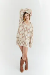 Sweater de lana color beige con diseño geométrico de rombos en tonos beige y blanco, cuello en V y corte holgado.