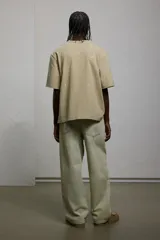 Pantalón de jean color crema, de corte holgado, con tiro bajo y cinco bolsillos.