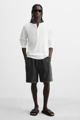 Sandalias tipo pala color beige con tira ancha en el empeine con relieve y suela de goma con volumen.