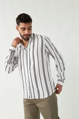 Camisa blanca con rayas verticales negras, de manga larga y corte regular.