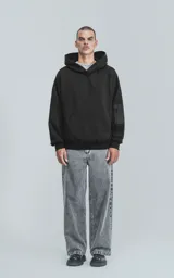 Hoodie negro oversize de rústico 100% algodón con capucha forrada y bolsillo tipo bomber con cierre en la manga.
