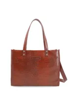 Cartera tipo shopper Hush Puppies color marrón con textura símil piel de cocodrilo. Tiene doble asa de hombro y correa extraíble regulable. Incluye logo de la marca en el frente.