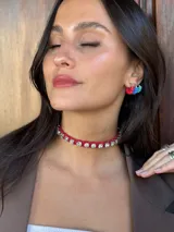 Gargantilla corta de gamuza trenzada color rojo con strass plateados. Se cierra con cadena y gancho para regular el largo.