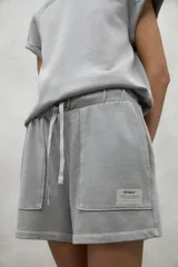 Shorts blancos de algodón orgánico y reciclado, con cintura elástica ajustable y bolsillos laterales.