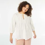 Blusa blanca con bordado calado, escote con lazo y mangas 3/4 abullonadas.