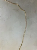 Collar dorado con cadena de bolitas.