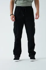 Pantalón cargo color beige, con cintura elástica ajustable con cordón, bolsillos laterales con cierre y bolsillos cargo con solapa.