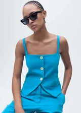 Chaleco azul con tirantes finos, escote cuadrado, cierre frontal con botones y espalda descubierta.